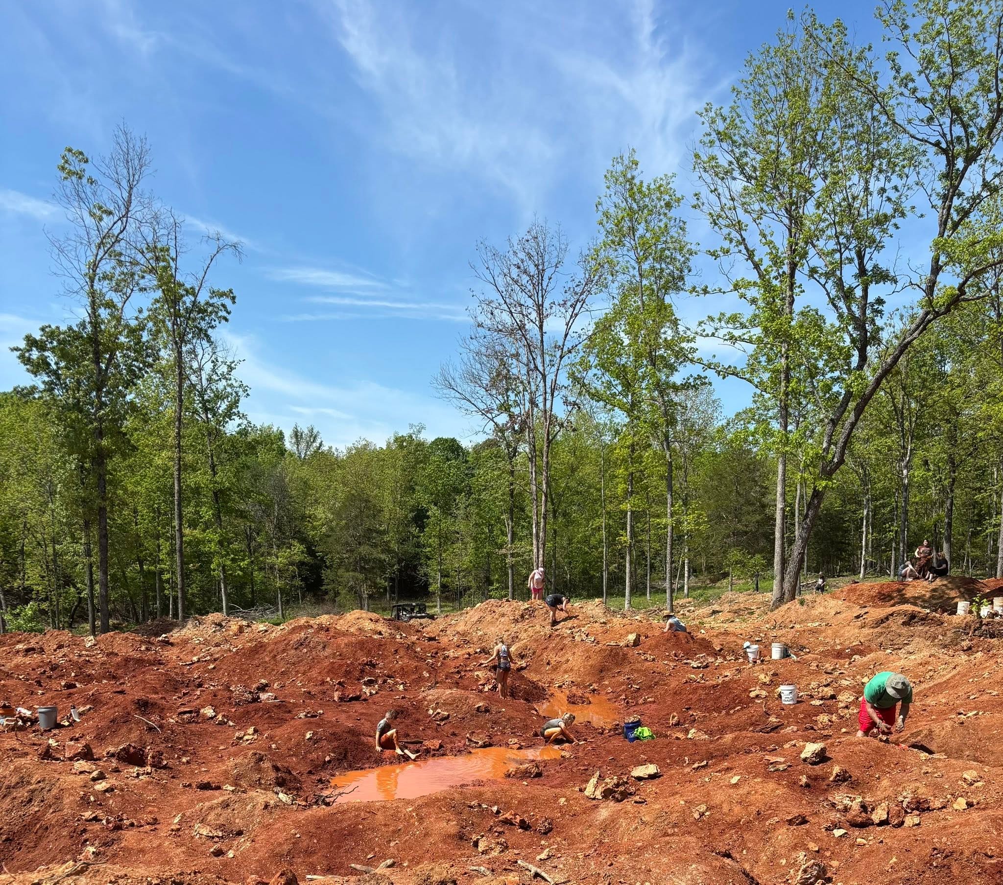 People searching the red earth at Rootbeer Ridge, Haunted Ridge Rocks